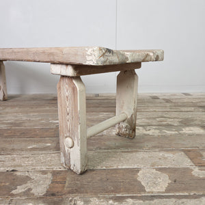 A vintage early 20th-century pine bench featuring a three-plank top and straight legs with circular lower stretchers. Suitable for hallway or boot room use, this farmhouse bench also works well as a dining bench or placed at the foot of a bed.