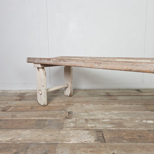 An early 20th-century rustic pine bench with a three-plank seat and straight legs joined by circular lower stretchers. This vintage bench works well in a hallway or boot room and can also be used as a dining bench or bedroom bench.