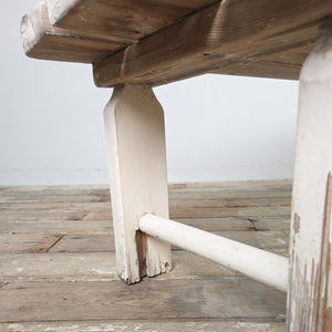An early 1900s antique rustic country pine bench with three planks forming the seat and straight legs joined by circular lower stretchers. Suitable for hallway use, at the foot of a bed, or as a simple dining bench in a kitchen.