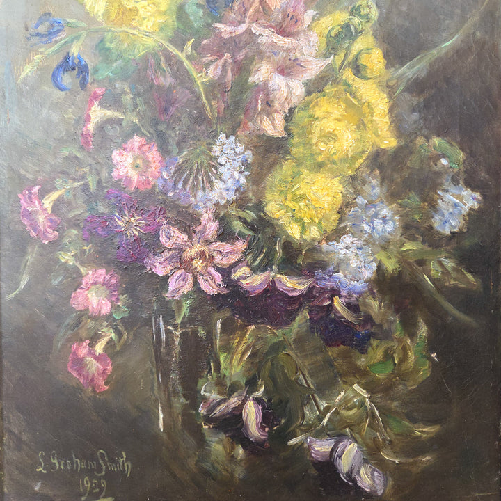 Early 20th-century oil painting depicting a vibrant arrangement of garden flowers. Signed and dated 1929 by L Graham Smith, this floral artwork is framed in a simple painted gilt frame, ready to hang in any room.
