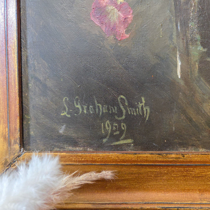 Original early 20th-century floral oil painting signed by L Graham Smith, dated 1929. Shows a colourful garden flower collection on canvas with a simple painted gilt frame.
