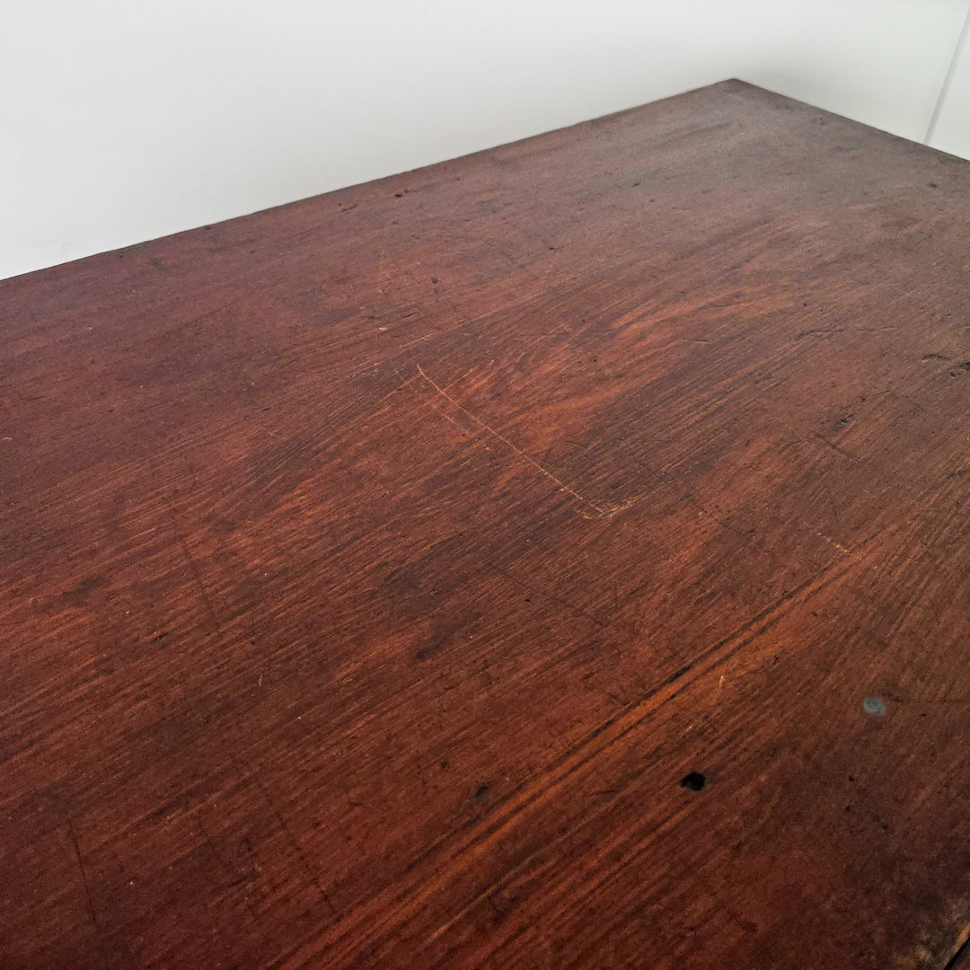 An early 20th-century dark stained pine chest with four drawers, each with brass cup handles. Built from solid pine with a moulded top, plinth base, and panelled sides, the chest displays the honest, functional design associated with country-made antique furniture.