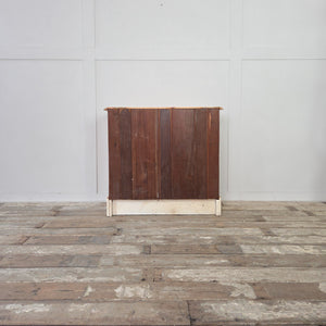 A solid antique pine chest of drawers, early 20th century in date, with four drawers in a two over two layout. Each drawer retains its original brass handles and escutcheons. The chest is raised on a plinth base with decorative cut-out, shows a natural pine patina, and is finished with moulded edges to the top.