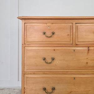 An early 20th century antique pine chest of drawers featuring two short drawers above two full-length drawers. Retains its original brass swan neck handles and escutcheons. The chest displays a natural pine patina, sits on a plinth base with decorative cut-out, and has moulded edges to the top, finished in wax.