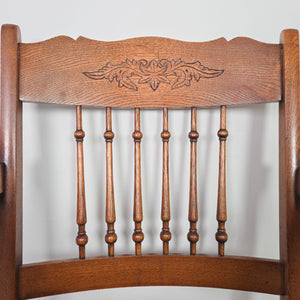 Antique oak occasional chair with Edwardian spindleback, floral carved crest rail, shaped armrests and a mustard velvet seat with stud detailing.
