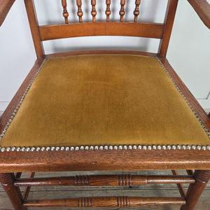 Edwardian oak accent chair in a farmhouse style form, featuring a spindleback chair design, decorative floral carving and a studded velvet seat.