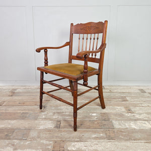 Edwardian oak occasional chair with spindleback design, floral carved detail, shaped armrests and a studded velvet seat.