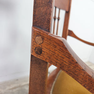 Antique farmhouse style oak spindleback chair with Edwardian floral carving to the crest rail and a studded velvet upholstered seat.