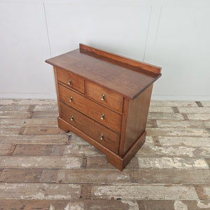 Early 20th century Edwardian oak chest of drawers with four drawers, brass drop handles, moulded edges to the top and a small raised upstand, finished with a shaped plinth base.
