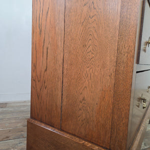 Edwardian oak chest of drawers from the early 20th century featuring four drawers, decorative brass drop handles, moulded edges to the top and a shaped plinth base.
