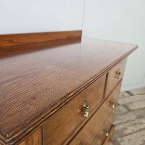 Early 20th century oak chest of drawers in the Edwardian period, with four drawers fitted with brass pear-drop handles, moulded top edges and a shaped plinth base.
