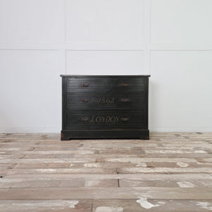 An early 20th century painted chest of drawers with four drawers and decorative brass handles. The chest has a dark green painted finish with lined borders and hand-painted lettering to the drawer fronts, along with a painted ship scene to the top. Constructed in mahogany veneer and suitable for use as a sideboard in a hallway.