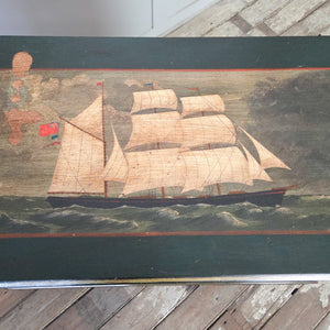 An antique painted pine chest from the early 20th century with four drawers in a two-over-two layout. The chest has a dark green painted finish with hand-painted lettering to the drawers and a ship scene painted to the top. Constructed in mahogany veneer and suitable for hallway or bedroom use.
