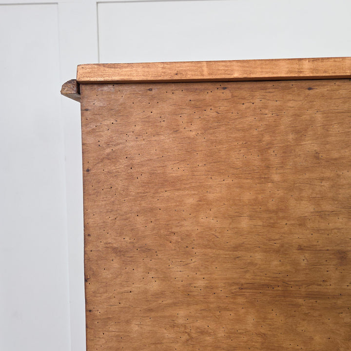 An Edwardian satinwood chest of drawers offering practical storage across four drawers in a two-over-two layout, each with reeded fronts and brass swing handles, raised on tulip-shaped feet and finished in Briwax Rustic Pine to enhance the satinwood grain.