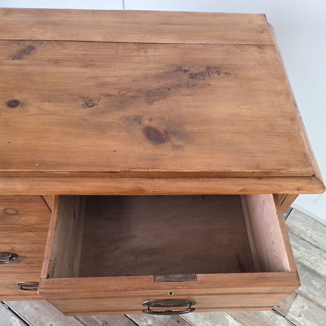 An early 20th century satinwood chest of drawers providing ample storage through four reeded-front drawers with brass swing handles, raised on tulip-shaped feet and sealed in Briwax Rustic Pine to protect the surface and enrich the grain.