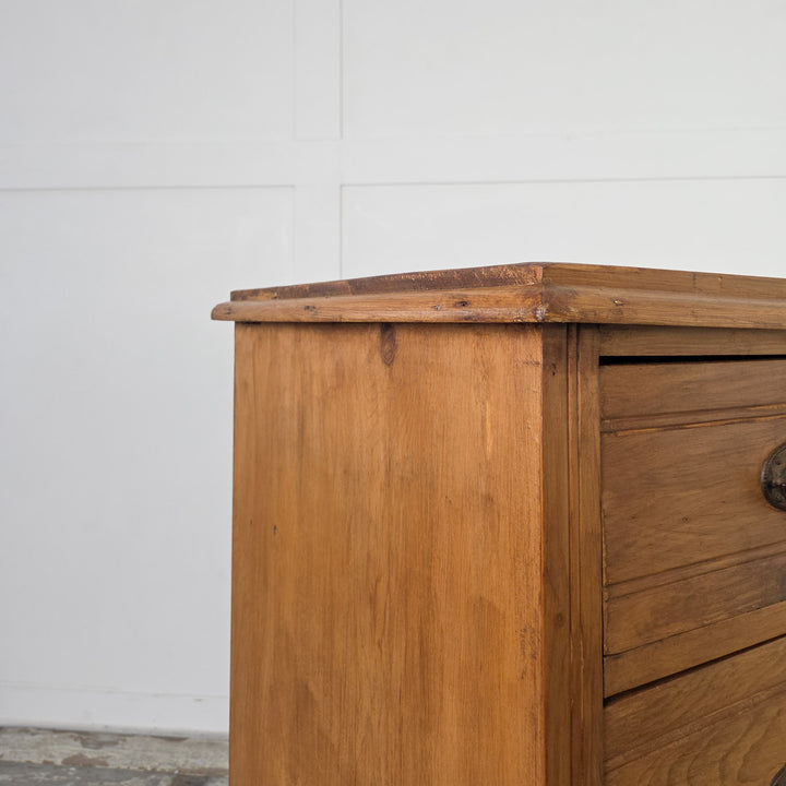 An Edwardian satinwood four-drawer storage chest with reeded drawer fronts, brass swing handles and tulip-shaped feet, finished in Rustic Pine wax for a mellow, protective sheen that brings out the warm tone of the satinwood.
