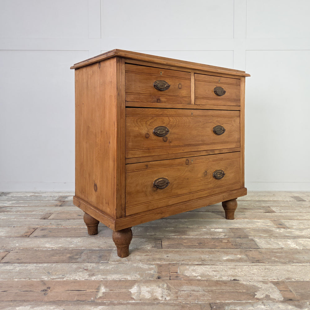 Antique satinwood chest of drawers from the Edwardian period offering generous storage across four drawers, each with reeded detailing and brass swing handles, raised on tulip feet and wax finished in Briwax Rustic Pine.