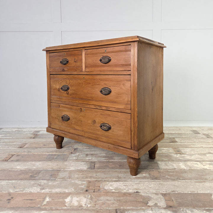 An Edwardian satinwood dresser or storage chest with four drawers featuring reeded detailing and brass swing handles, supported by tulip-shaped feet and sealed in Briwax Rustic Pine to enhance and protect the satinwood surface.