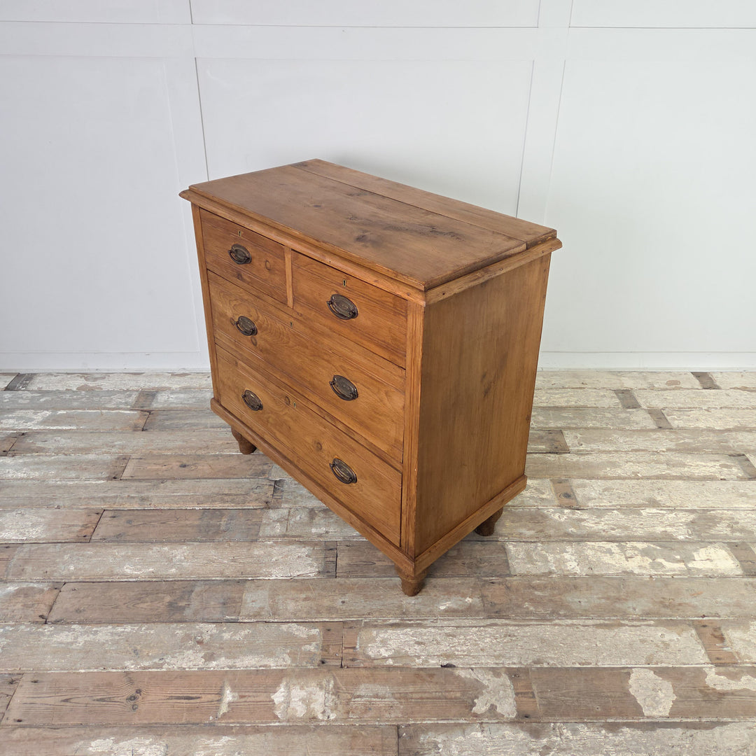 An antique satinwood storage chest with four drawers, reeded detailing and brass swing handles, raised on tulip-shaped feet and finished in Rustic Pine wax for a soft sheen and protection while preserving the natural character of the wood.