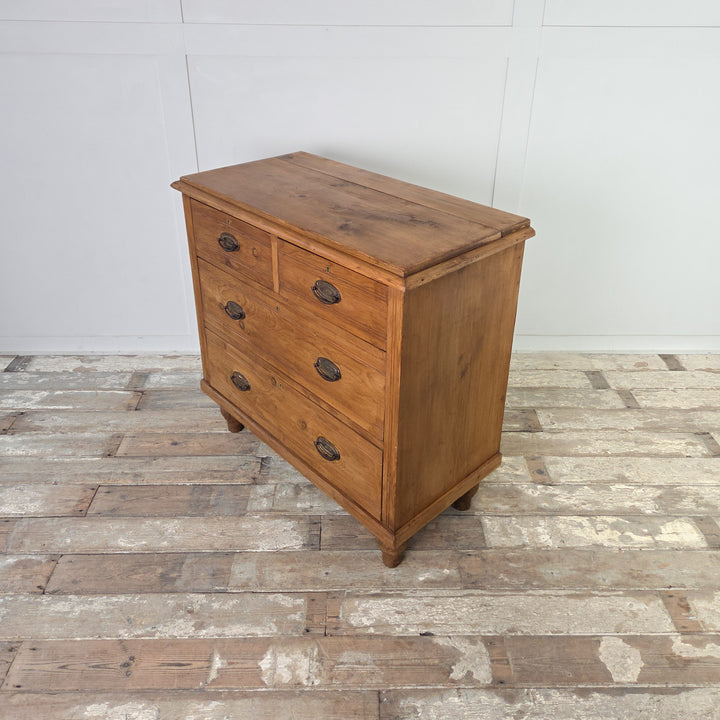 An antique satinwood storage chest with four drawers, reeded detailing and brass swing handles, raised on tulip-shaped feet and finished in Rustic Pine wax for a soft sheen and protection while preserving the natural character of the wood.