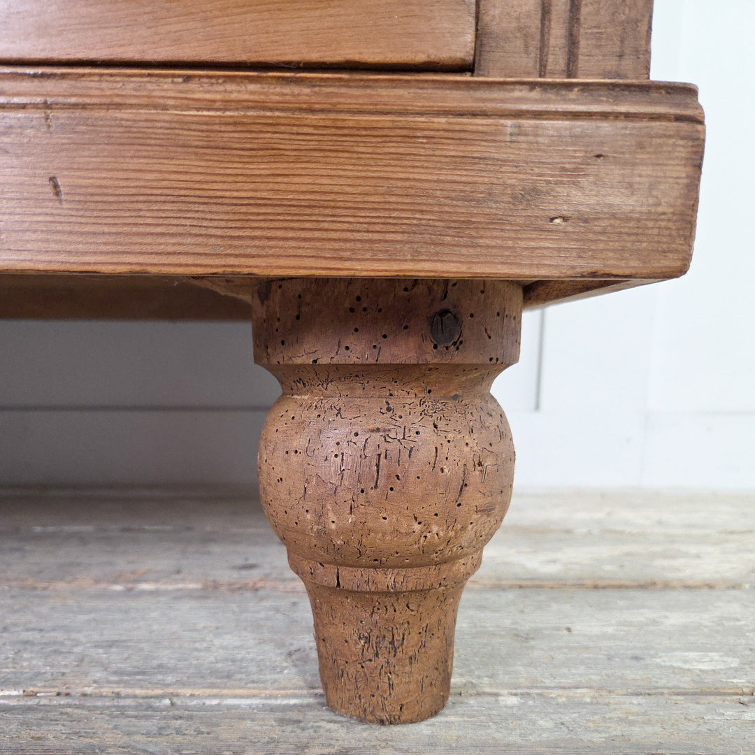 An early 20th century satinwood storage chest with four drawers, reeded fronts and brass swing handles, raised on tulip-shaped feet and finished in Briwax Rustic Pine to protect and enrich the satinwood patina.