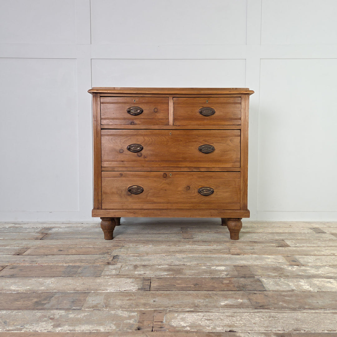 An antique satinwood storage chest from the Edwardian period with four drawers, brass swing handles and reeded fronts, raised on tulip-shaped feet and sealed in Rustic Pine wax to enhance the satinwood tone and grain.