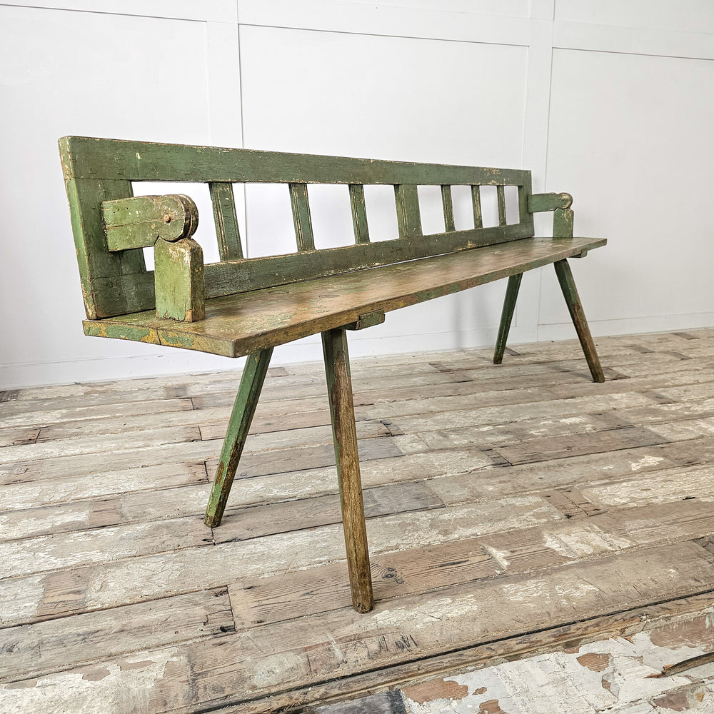Continental stick leg bench with green painted surface
