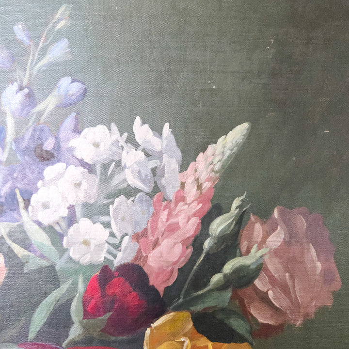 Mid 20th century floral oil painting signed by Thomas Bradley, showing a vase of flowers in shades of pink and yellow contrasted against a dark ground. The still life composition is painted on board and set within a decorative painted frame, highlighting its traditional subject and style.