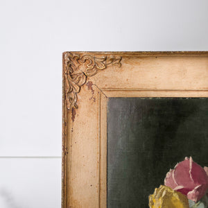 A signed floral still life oil painting on board by Thomas Bradley, mid 20th century, featuring a vase of pink and yellow flowers arranged against a darker background. The painting is presented in a decorative painted frame, enhancing the subject and giving it presence as wall art.