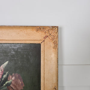 A mid 20th century still life oil painting by Thomas Bradley, signed to the lower left, showing a decorative vase with flowers in radiant pinks and yellows. Painted on board and framed in painted wood, the composition contrasts the bright blooms against a dark background.
