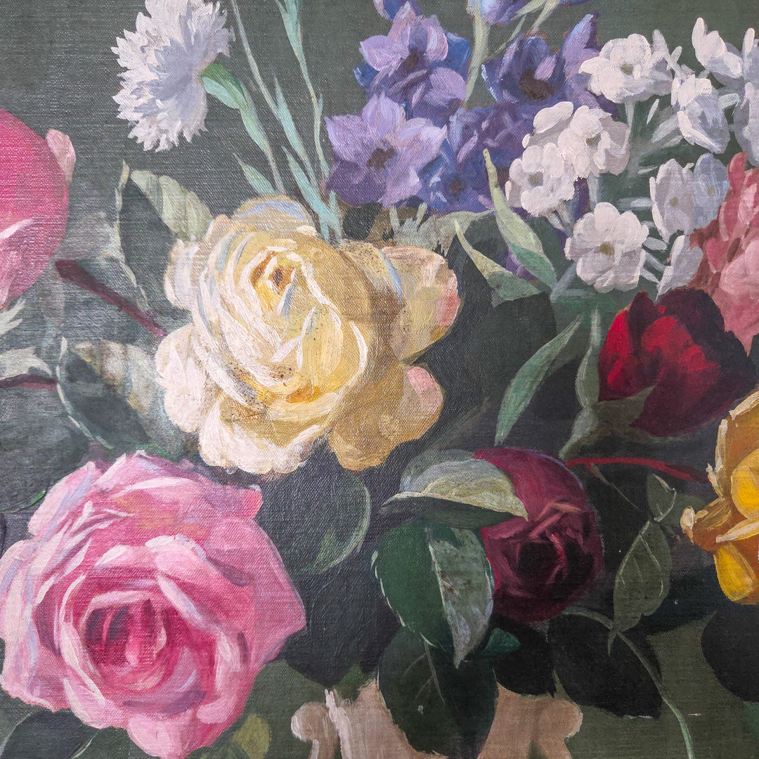 Mid 20th century vintage floral oil painting on board, signed, depicting a decorative vase of flowers in soft pinks and golden yellows. The blooms are set against a darker background for contrast, with a painted frame adding a complementary border to the traditional still life subject.