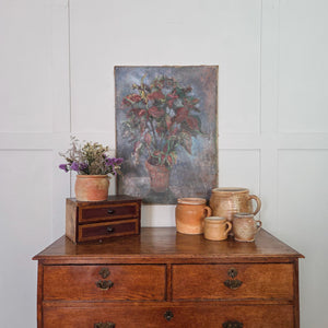 French oil painting, early 20th century, showing a terracotta pot of foliage with deep red and green leaves. The expressive brushwork and muted background give a sense of quiet domestic warmth.