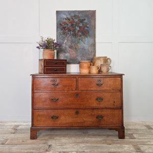 Early 20th century French oil painting depicting a potted plant with red and green leaves set against a softly toned blue-grey background. The worn surface and subdued palette add to its rustic appeal.