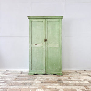 A French green painted cupboard from the early 1900s featuring two doors, eight internal drawers and slatted bases. The original paint, shaped plinth and cornice give this antique storage cupboard a cottage and country character while offering generous organised storage in a compact form.