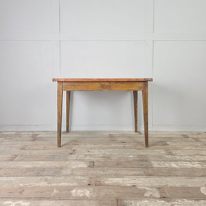 Antique French farmhouse table with mustard yellow painted base and original linen-covered top on slender tapering legs 