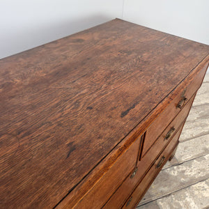 Early 19th century antique Georgian oak chest with four drawers, original brass fittings and bracket feet. The surface displays a fine warm patina typical of well-aged oak furniture.
