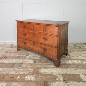 A handsome early 19th century Georgian oak chest of drawers featuring four graduated drawers, original brass fittings and bracket feet. A well-made period piece perfect for bedroom or hallway storage.
