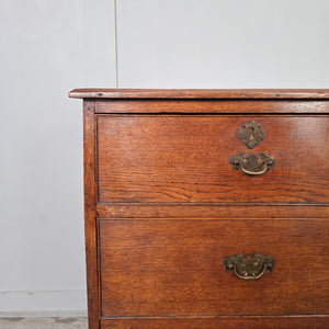 Antique Georgian oak chest of drawers dating from the early 19th century, arranged in a two-over-two format with original brass fittings and bracket feet. The oak has matured into a deep, mellow tone, showing gentle wear that adds to its period charm and authenticity.
