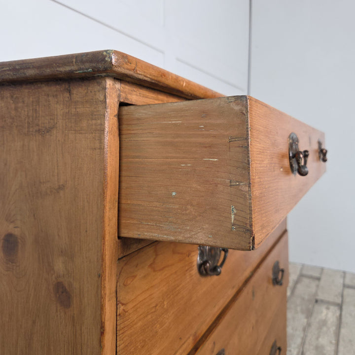 A 19th-century Georgian chest of drawers crafted from solid pine with brass pull handles and shaped bracket feet. A traditional antique furniture piece that captures the character of English farmhouse and Georgian country furniture.