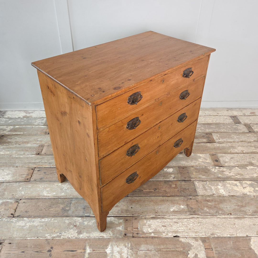 An early 19th-century English Georgian pine chest of drawers with five drawers, brass fittings and bracket feet. A practical antique storage chest suited to bedroom, hallway or living room interiors styled with rustic Georgian and country furniture
