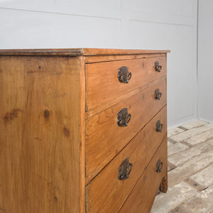 A Georgian pine chest of drawers from the early 1800s featuring five drawers with brass pulls, shaped apron and bracket feet. A well-made piece of antique English pine furniture, showcasing the simple charm and quality typical of farmhouse furniture from the period.