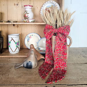 Festive wall bow with plush padding and brass ring
