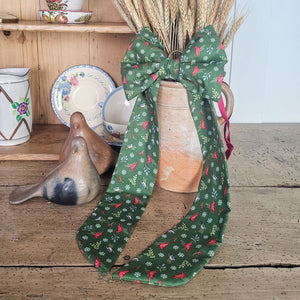 Handmade festive bow with padded body and brass ring.
