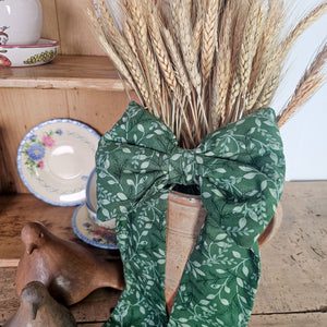 Plump handmade bow with festive patterns and velvet hanging ribbon.
