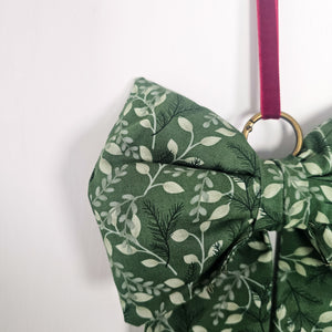 Festive bow with plush design and brass ring for Christmas tree.
