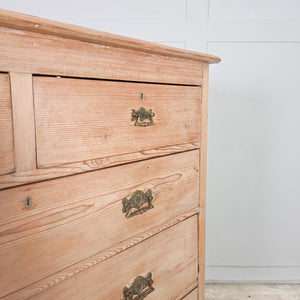 An antique Victorian pine chest of drawers featuring five drawers and decorative brass handles. The stripped pine finish and simple plinth base make it a practical option for bedroom drawers or hallway storage.