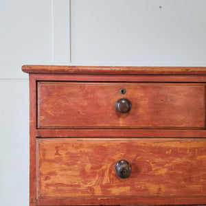 Painted pine chest of drawers from the Victorian era featuring original red finish, five drawers and wooden knobs. Raised on classic bun feet, sealed with wax. Antique furniture ideal for rustic interiors, farmhouse bedrooms or hallways with traditional character.