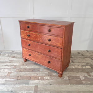 Substantial Victorian pine chest of drawers featuring red painted finish and five drawers with original knobs. Raised on bun feet and finished with clear wax. Antique storage ideal for farmhouse bedroom, rustic hallway or as a painted pine sideboard in the home.