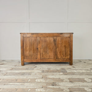 Early 20th-century antique pine storage chest with a hinged lid, two interior sections and decorative panelled sides. The waxed pine finish brings out the natural grain, giving this wooden trunk a farmhouse and country character while providing substantial storage space for linens, textiles and home items.