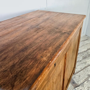 An antique wooden trunk in pine with a lift-up hinged lid, internal dividers and block feet. The waxed surface brings out the natural grain and colour, creating a farmhouse-style blanket box offering organised storage in a solid early 20th-century form.